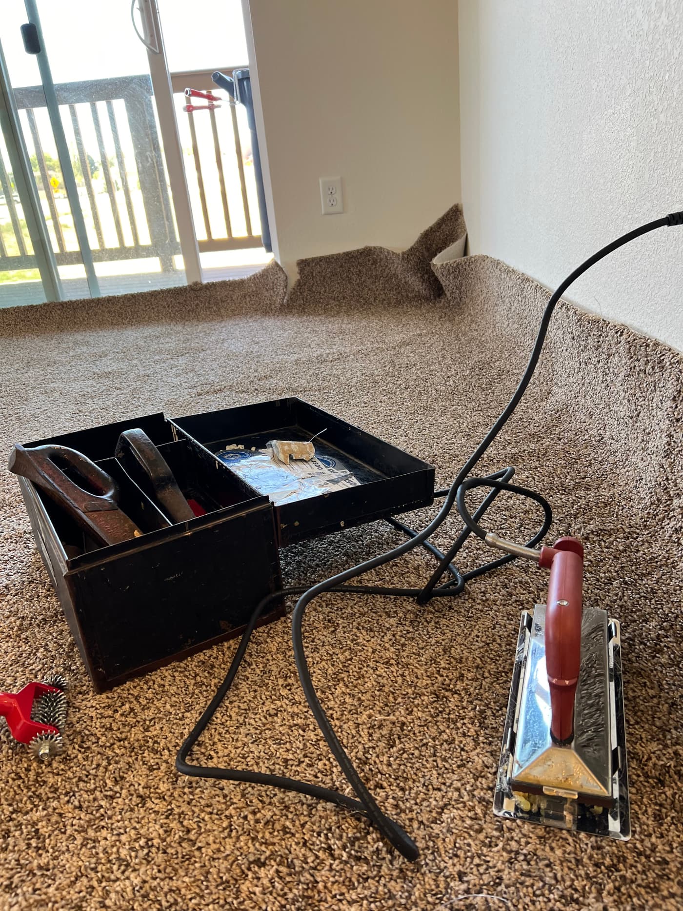 Carpet installation in progress with seam iron and professional tools